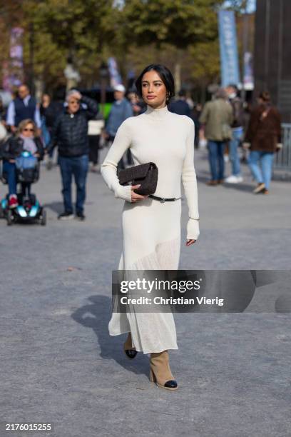 Kelsey Merritt wears knitted dress, brown bag, suede boots outside Chanel during Womenswear Spring/Summer 2025 as part of Paris Fashion Week on...