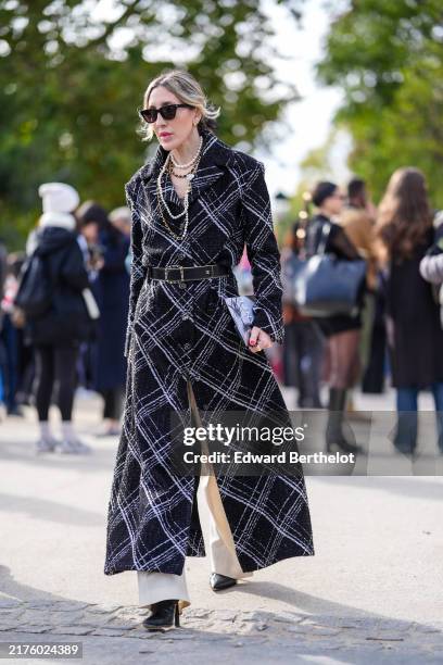 October 1 : A guest wears sunglasses, silver earrings, white layered beaded necklaces, black white pattern tweed Chanel coat, shiny black belt, white...
