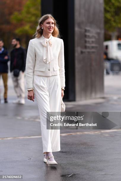 October 1 : A guest wears silver earrings, white tied bow long sleeve shirt, white tailored blazer jacket, white loose pants, gold bracelets, white...