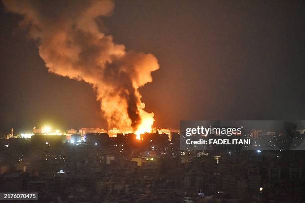Fire and smoke rise at an area targeted by an Israeli airstrike on Beirut's southern suburb on October 6, 2024. Official Lebanese media said five...
