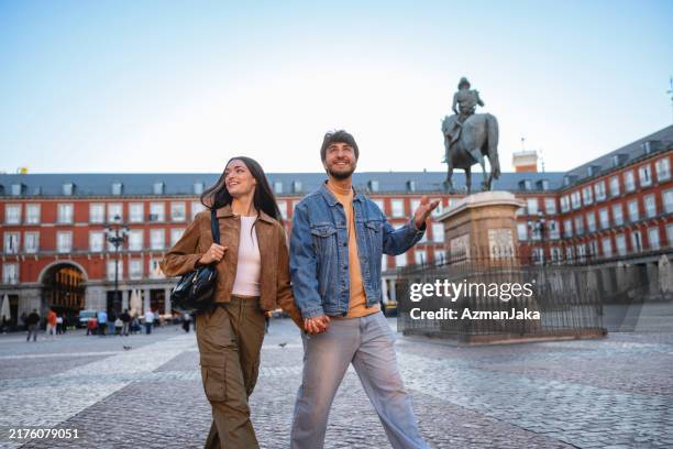 hispanic couple enjoying visit to plaza mayor in madrid - madrid stock pictures, royalty-free photos & images