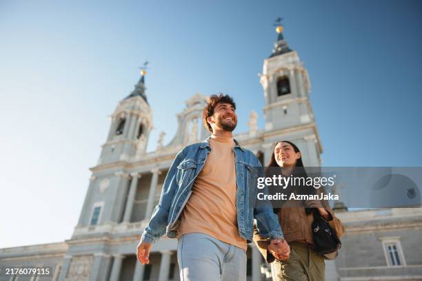 hispanic couple enjoying sightseeing at almudena cathedral in madrid - madrid stockfoto's en -beelden