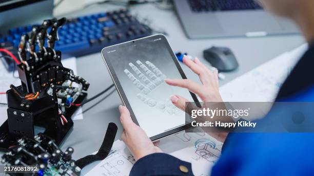 primer plano ingeniero desarrollador trabajando en 3d robot modelo de brazo prototipo en una tableta digital programa de pruebas componentes de software mecánico movimiento de la mano - tecnología sanitaria fotografías e imágenes de stock