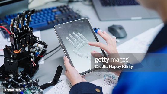 Close up engineer developer working 3D robotics arm model prototype on a digital tablet testing program mechanical software components hand movement Close up engineer developer working 3D robotics arm model prototype on a digital tablet testing program mechanical software components hand movement