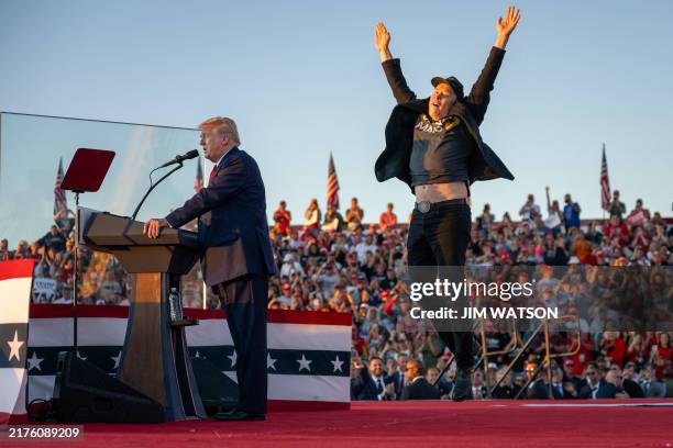 Tesla CEO Elon Musk jumps on stage as he joins former US President and Republican presidential candidate Donald Trump during a campaign rally at site...