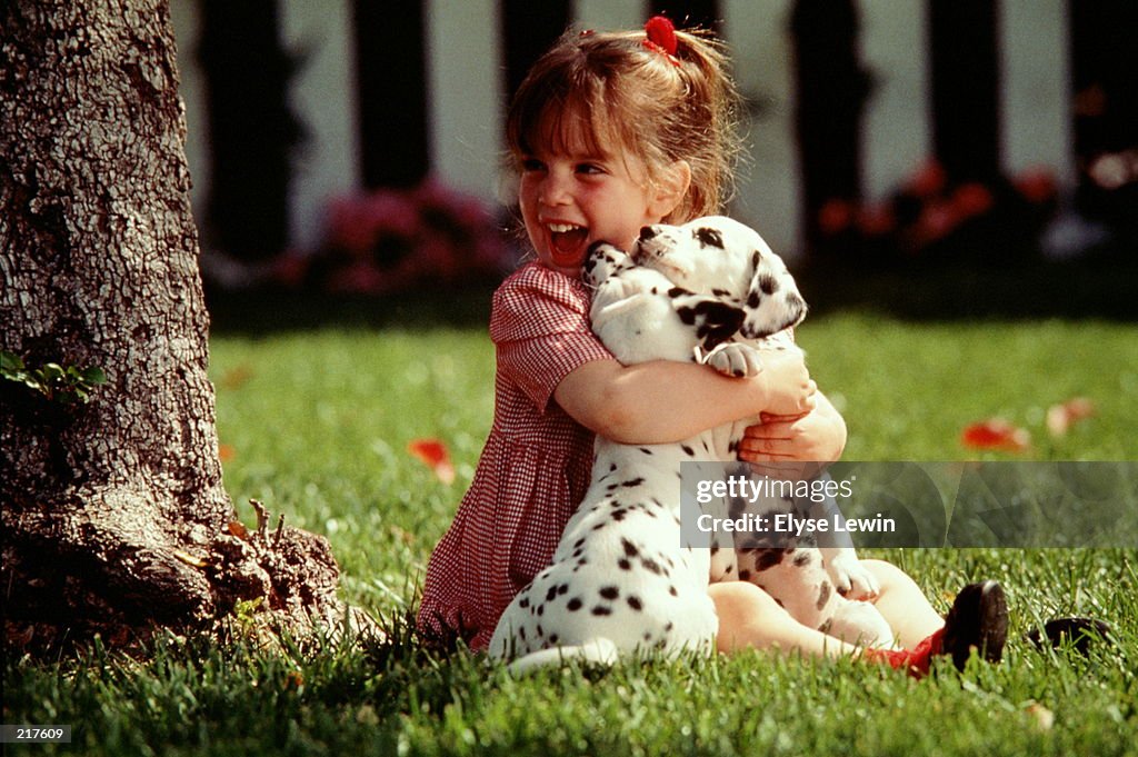 GIRL HUGGING DALMATIAN PUPPIES