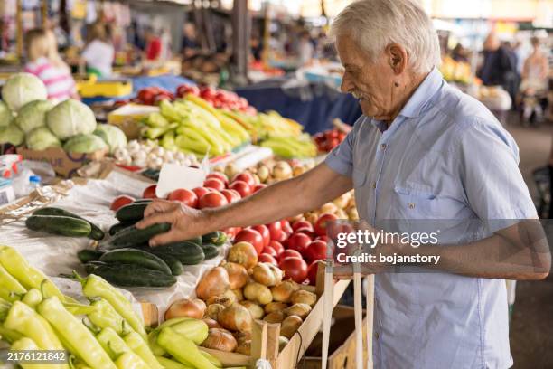 hombre mayor comprando productos orgánicos frescos en el mercado de agricultores - puesto de mercado agrícola fotografías e imágenes de stock