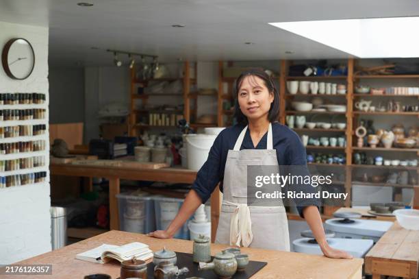 a portrait of a ceramcist in her studio - apron stock pictures, royalty-free photos & images
