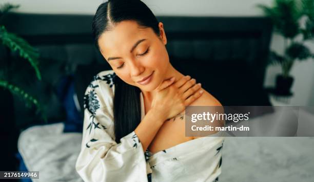 woman at home using shea butter body cream - neck cream stock pictures, royalty-free photos & images