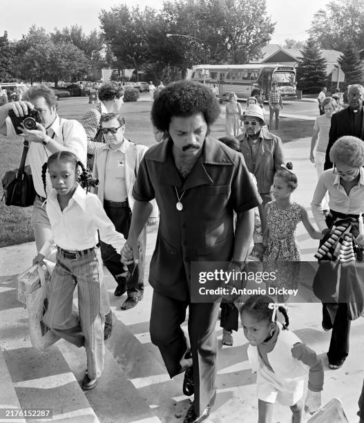 American Civil Rights activist & politician Reverend Jesse Jackson holds the hands of two African-American girls on the first day of a voluntary...