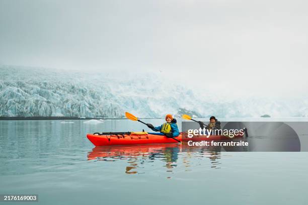 mutter und sohn mit dem kajak zu einem gletscher in alaska - kajakdisziplin stock-fotos und bilder