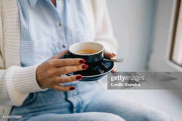 woman enjoying black coffee in a casual outfit at home - nail varnish stock pictures, royalty-free photos & images