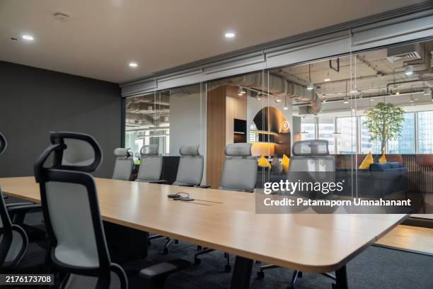 a sleek, modern meeting room designed for corporate business, showcasing stylish office furniture, a spacious conference table, and ample natural light. this empty workspace reflects professionalism and innovation, offering an ideal environment. - leeg bureau stockfoto's en -beelden