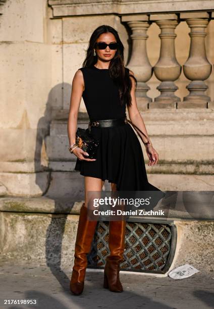 Kelsey Merritt is seen wearing a black Louis Vuitton dress, black belt, brown knee high boots and black Louis Vuitton bag with black sunglasses...