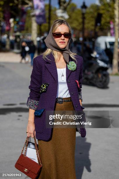 Guest wears head scarf, purple jacket, brown pants, red bag outside Chanel during Womenswear Spring/Summer 2025 as part of Paris Fashion Week on...