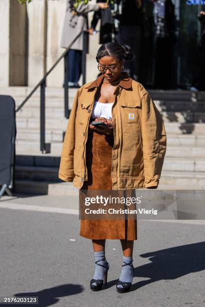 Guest wears beige jacket, brown suede skirt outside Peter Do during Womenswear Spring/Summer 2025 as part of Paris Fashion Week on October 01, 2024...