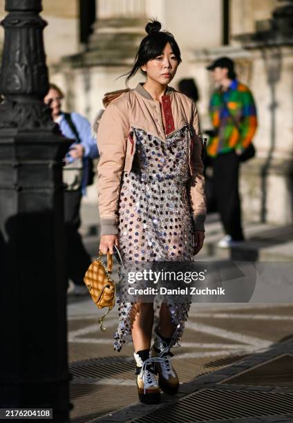 Susie Lau is seen wearing a light pink and gray jacket, sequin sheer Louis Vuitton dress, tan Louis Vuitton bag and Louis Vuitton high top sneakers...