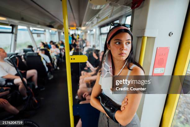young woman standing on train looking out of window - public transport stock pictures, royalty-free photos & images