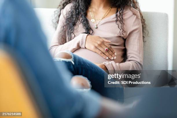 vue en contre-plongée avec mise au point sur une jeune femme enceinte - remplacement photos et images de collection