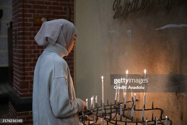 Woman lights candles at Dominicuskerk Church where people gather to commemorate Palestinians who have lost their lives in the past year as one year...