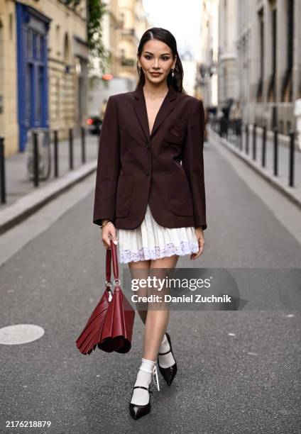 Alyssa Daguise is seen wearing a burgundy Lacoste blazer, white Lacoste panel skirt, black shoes white socks and red Lacoste bag outside the Lacoste...