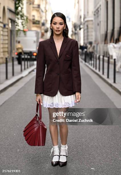 Alyssa Daguise is seen wearing a burgundy Lacoste blazer, white Lacoste panel skirt, black shoes white socks and red Lacoste bag outside the Lacoste...