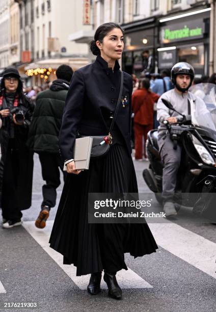 Caroline Issa is seen wearing a black jacket, panel skirt, black boots and gray bag outside the Lacoste show during Womenswear Spring/Summer 2025 as...