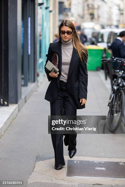 Guest wears black blazer, grey turtleneck, pants outside Lacoste during Womenswear Spring/Summer 2025 as part of Paris Fashion Week on October 01,...
