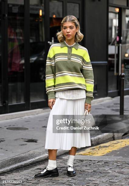 Ines Isaias is seen wearing a green striped Lacoste sweater, white shirt, white panel skirt, white socks, black shoes and Lacoste white bag outside...