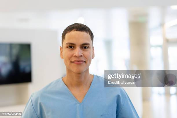 portrait of a young nurse standing in hospital - male nurse stock pictures, royalty-free photos & images