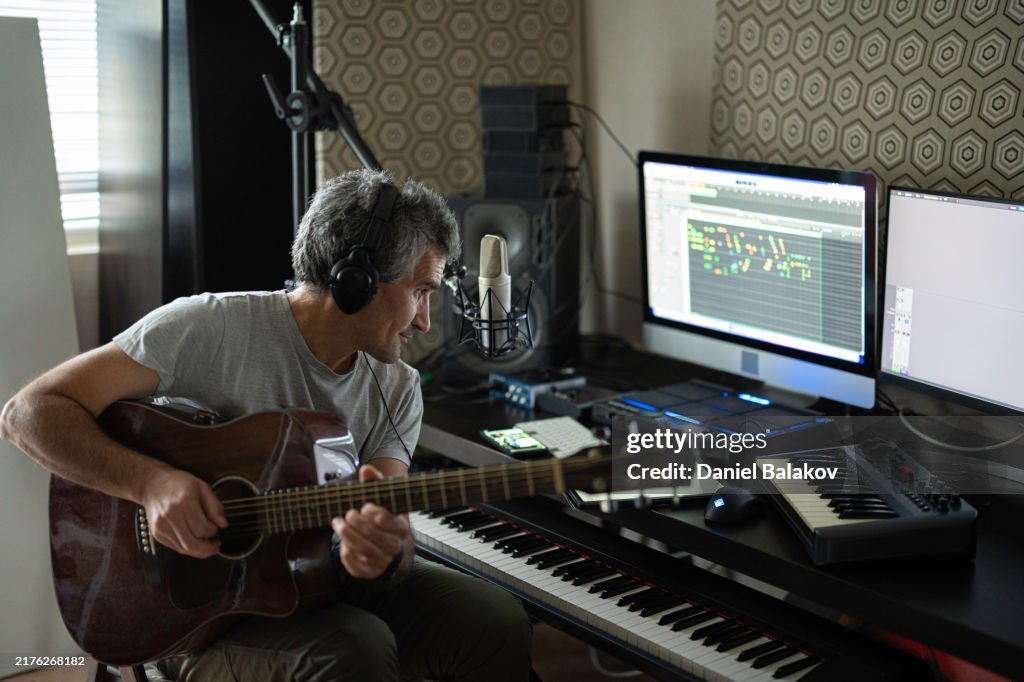 Musician Playing Acoustic Guitar In Home Music Studio
