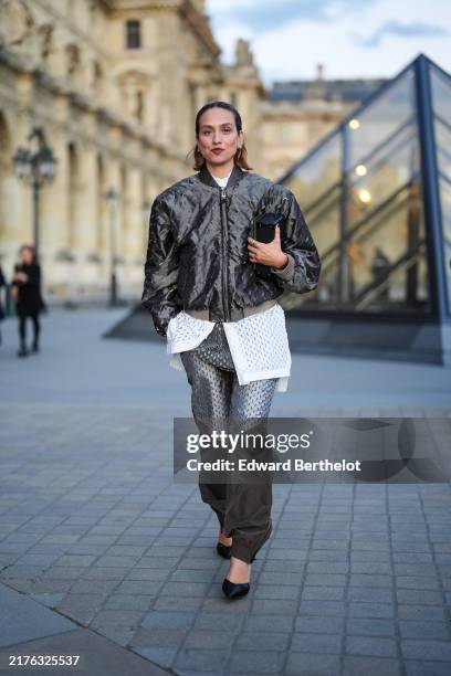 Erika Boldrin wears shiny black bomber jacket, white sheer mesh shirt, dark gray monogram pattern/print shirt, dark brown monogram pattern/print...