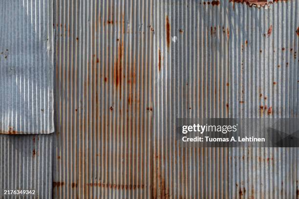 front view of a rusty and weathered corrugated iron metal construction site wall. - tôle ondulée photos et images de collection