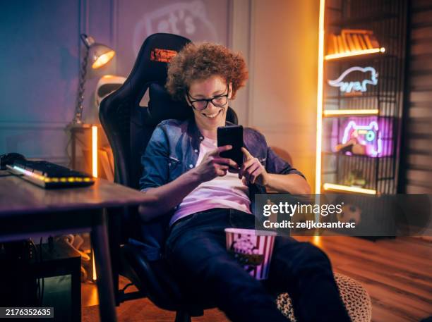teenage boy playing mobile game at home - redhead gamer stock pictures, royalty-free photos & images