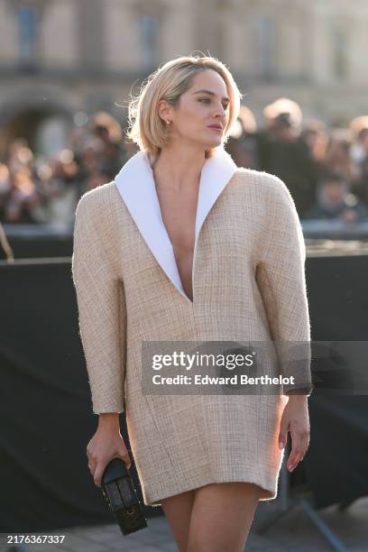 Noemie Merlant wears gold hoop earrings, white collar light yellow pattern broad shoulder Louis Vuitton mini dress, dark brown monogram pattern/print...