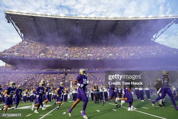 Washington Huskies players run onto the field before their game against the Michigan Wolverines at Husky Stadium on October 5, 2024 in Seattle,...