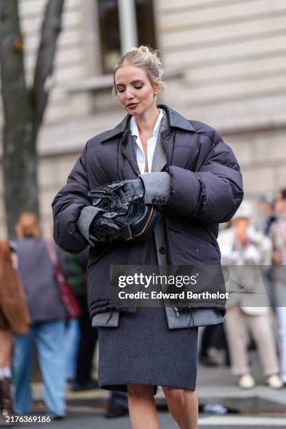 Leonie Hanne wears white Miu Miu bralette, white buttoned up long sleeve tied shirt, dark gray Miu Miu blazer jacket, black high waisted Miu Miu over...