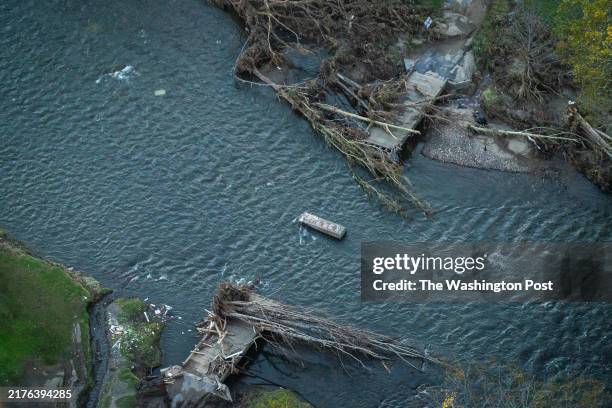 Ashe County, NC A destroyed bridge and debris is seen as National Guard soldiers look for people in distress as they scan the New River carrying...