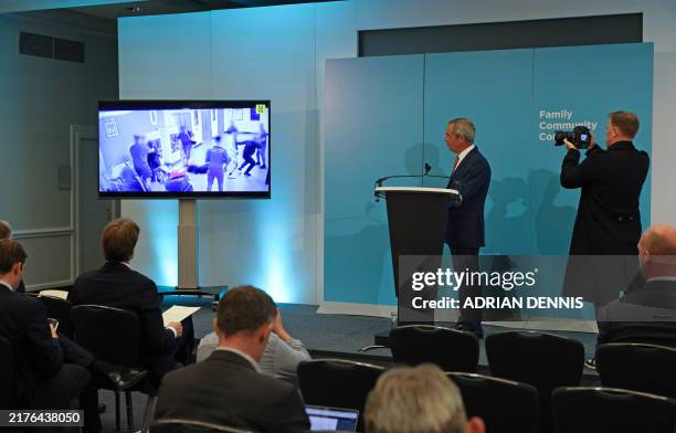 Leader of Reform UK, Nigel Farage , watches a video taken from social media, showing an incident at Manchester Airport on July 23 where a police...