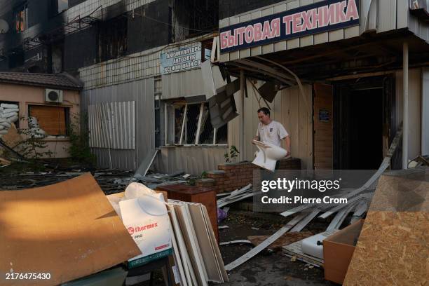 Entrepreneurs and employees from various businesses, including shops and a restaurant, rush to salvage belongings, stock, and furniture from a...