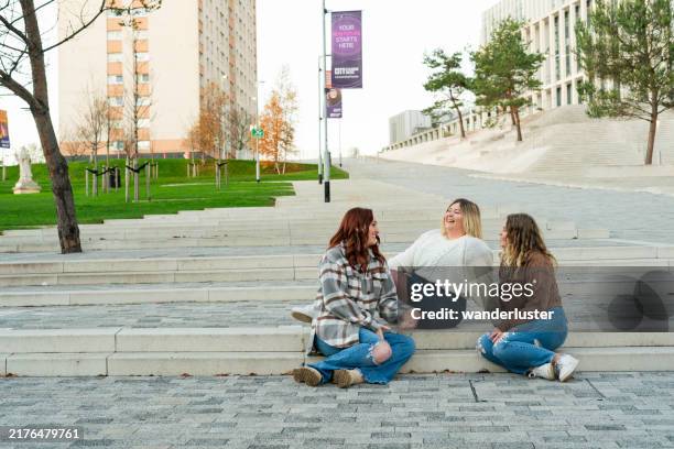 three college students take a break on steps at the university of strathclyde in glasgow - strathclyde stock pictures, royalty-free photos & images