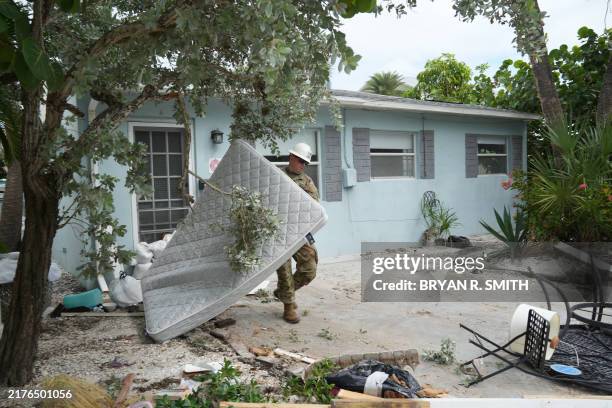 Florida Army National Guard member works to remove debris in the Pass-A-Grille section of St. Petersburg ahead of Hurricane Milton's expected...