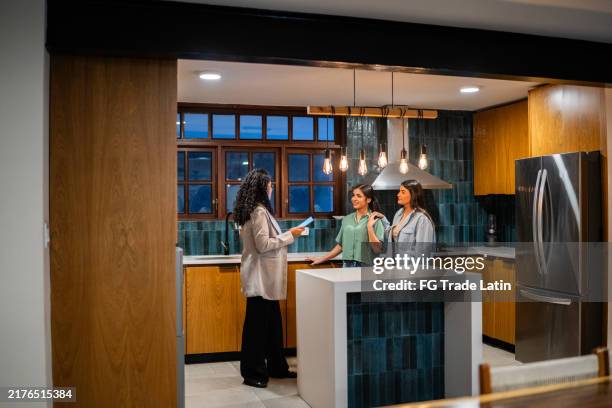 real estate agent showing house to customer couple - saleswoman stock pictures, royalty-free photos & images