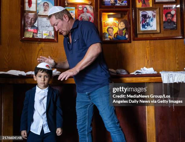 Los Angeles, CA Comedian Bill Dawes helps 6-year-old Isaac Masada with his kippah at the Laugh Factory where Masadas father Jamie, owner of the...