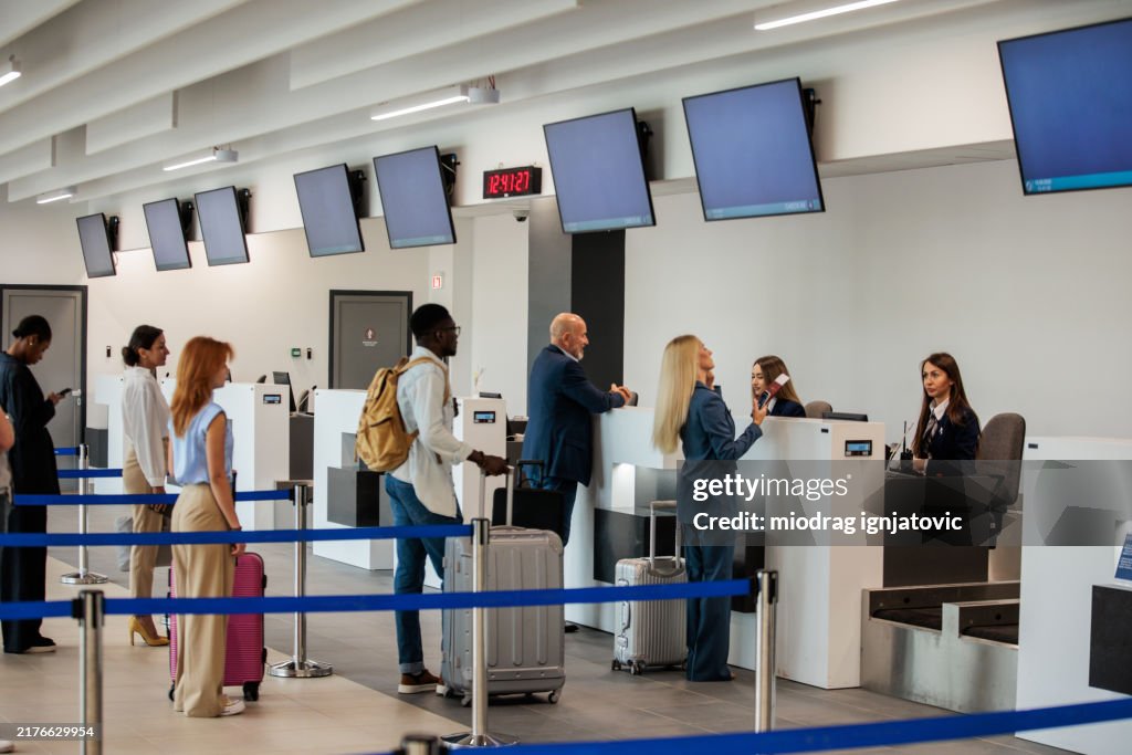 People waiting in a check-in line at an airport terminal