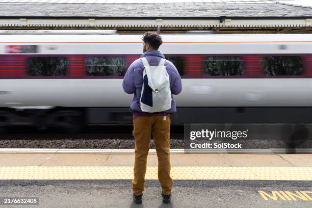 man watching a fast train pass by - waiting stock pictures, royalty-free photos & images