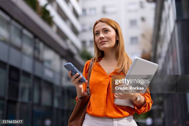 elegante donna d'affari che usa il suo telefono - business woman foto e immagini stock