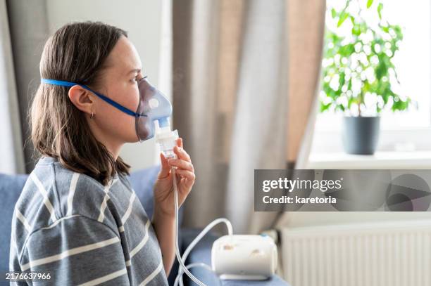 woman is using inhaler at home - exhaling stock pictures, royalty-free photos & images