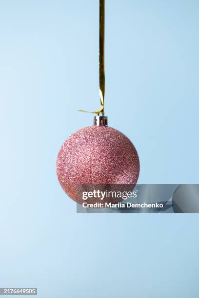pink glitter christmas bauble against blue background - knick knack stock pictures, royalty-free photos & images
