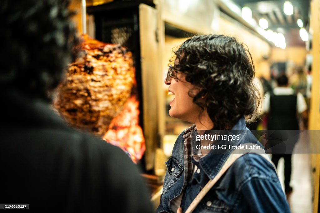 Junge Touristin schaut sich traditionelles Essen im Restaurant an